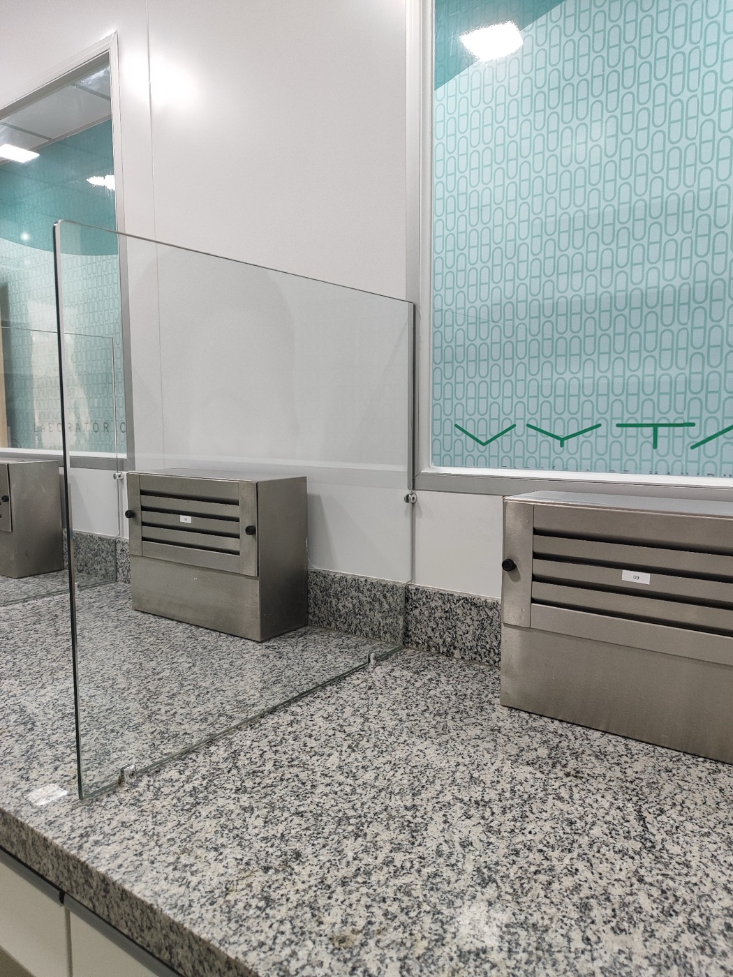 Bancada de granito com divisórias de vidro e exaustores de bancada em inox
